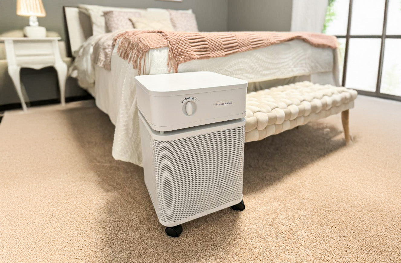 Austin Air purifier on a carpeted floor in a bedroom setting