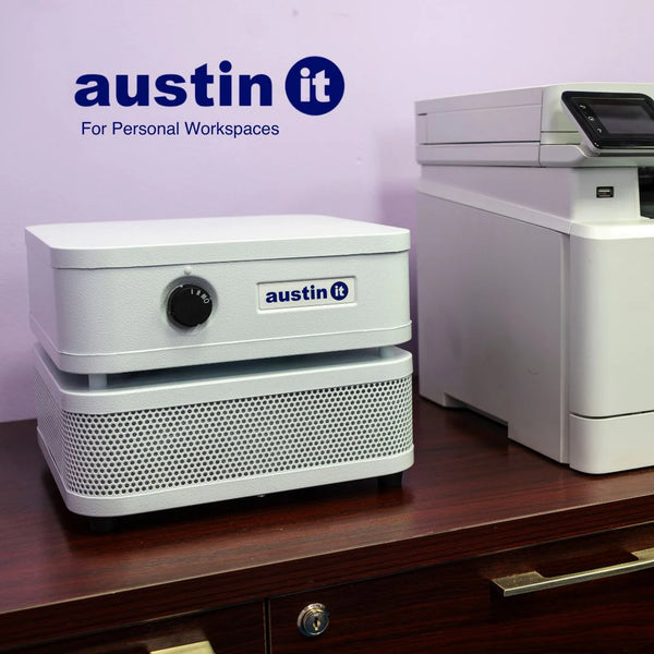 White air purifier on a wooden desk next to a printer