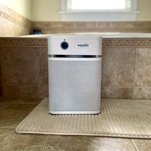 Air purifier on a bath mat in a bathroom setting