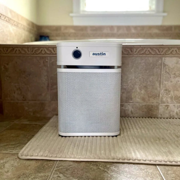 Air purifier on a bath mat in a bathroom setting