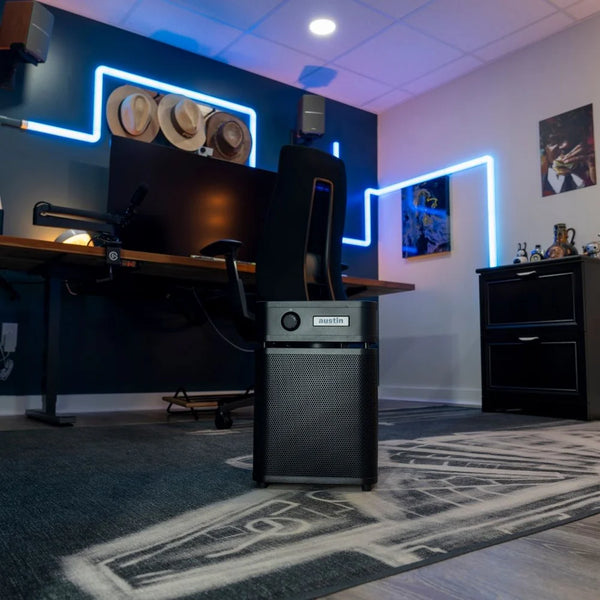 Computer setup in a room with neon lights and decor and a black air purifier